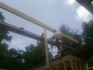 Carpenter setting a ridge beam over a new addition frame — Ice Dam Removal by Roofing Brothers in Hyannis