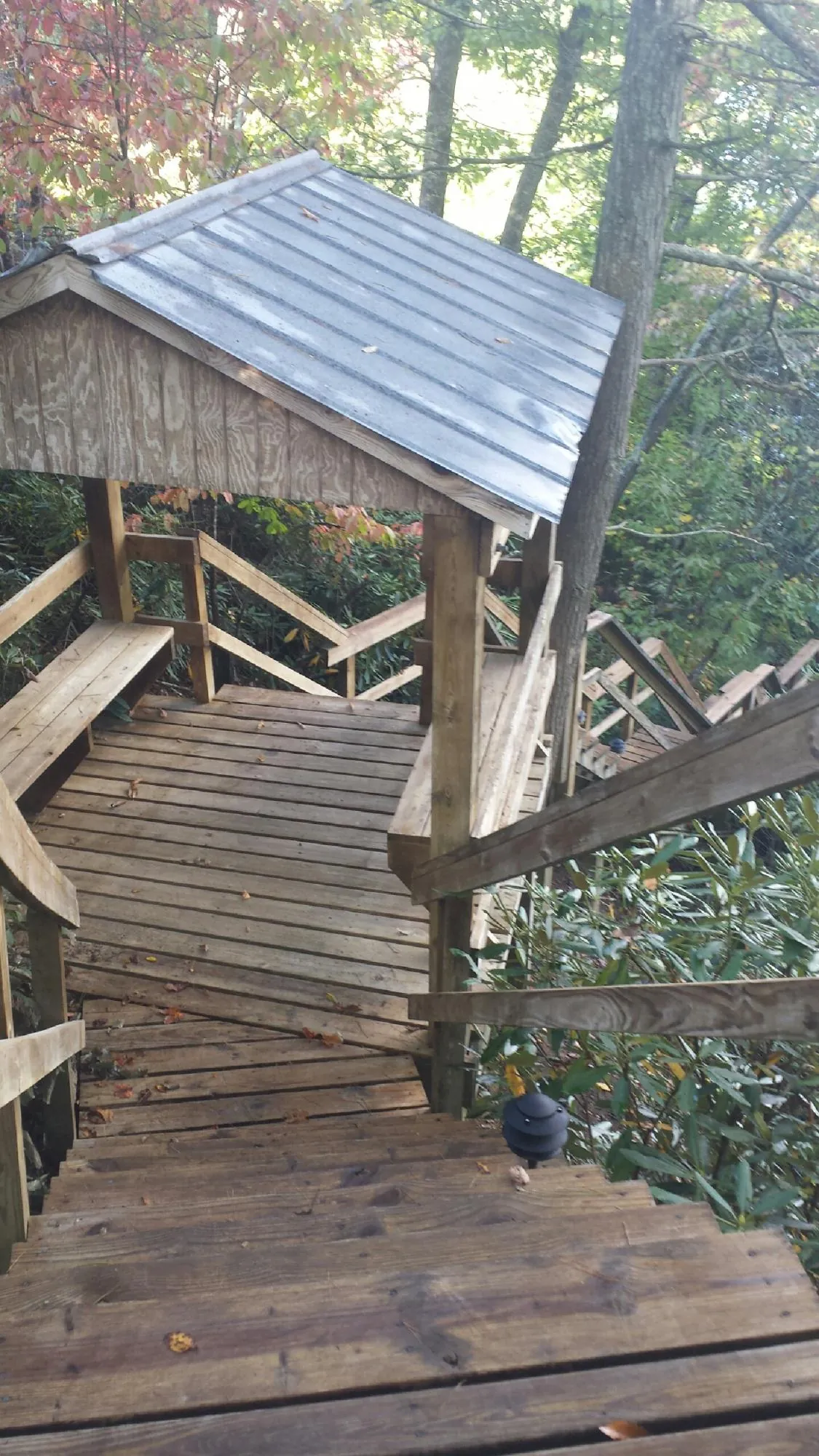Metal roofed shelter over wooden steps on a wooded walkway — Skylight Repair & Installation work by our crew in Hyannis
