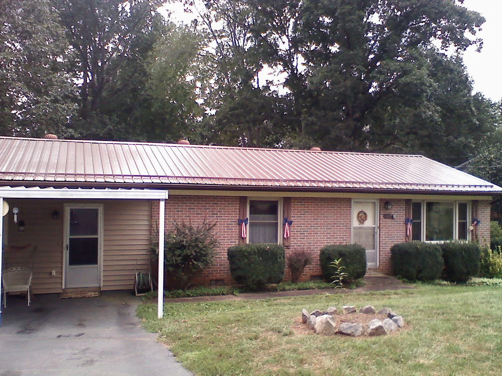 Bronze metal roof and carport on a brick ranch home — Roof Repair work by our crew in Hyannis